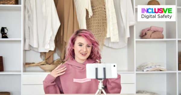 Un adolescent aux cheveux roses s'enregistre avec son smartphone.